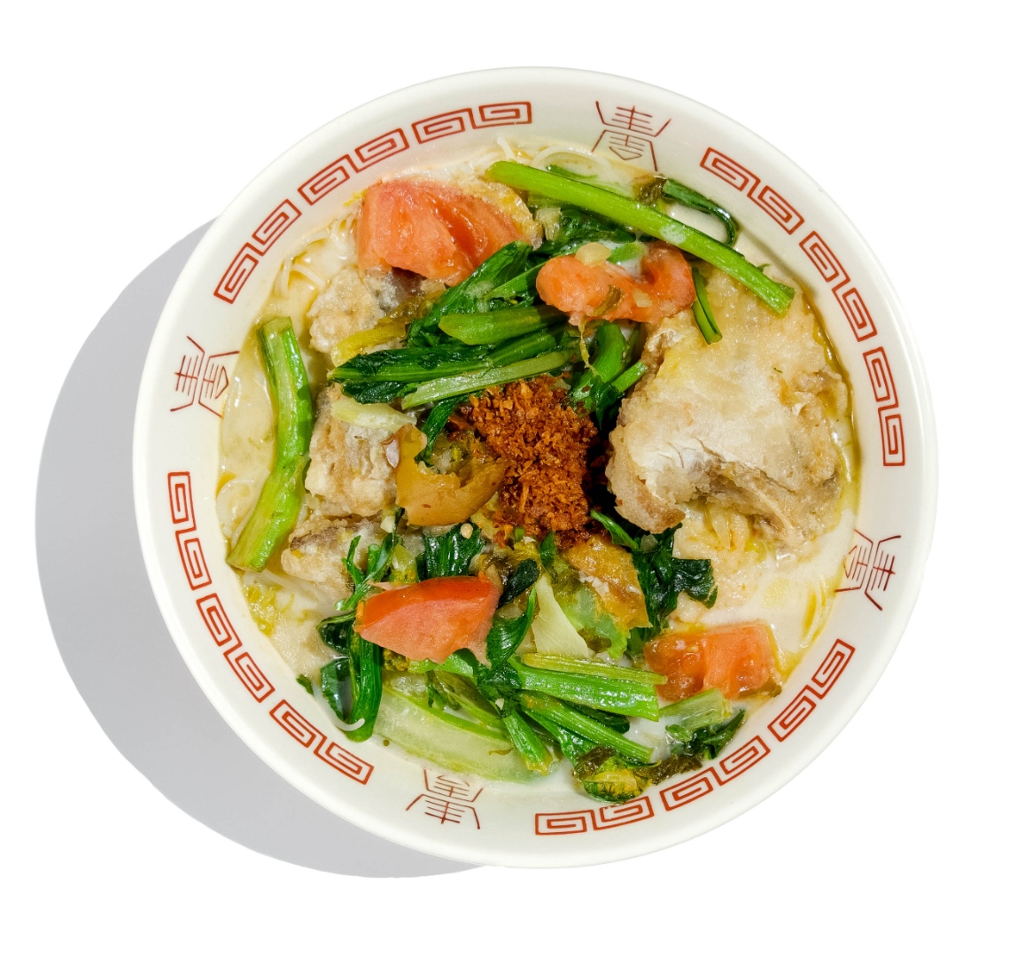 Fish head noodle soup with tomatoes and Chinese greens